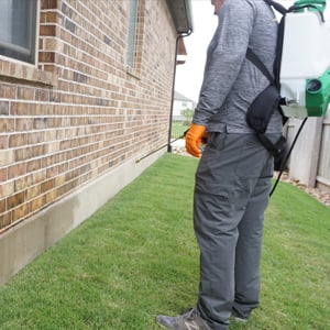 Emerald Lawns technician applying exterior pest control treatment at a home in Fort Worth, TX