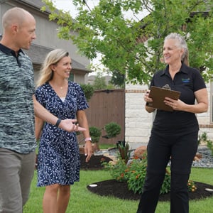 Emerald Lawns team member talking with customers on their lawn in Fort Worth, TX