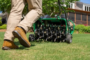 ace of blades lawn technician aerating lawn in Bentoville