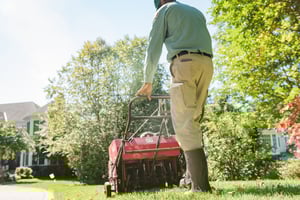 lawn care technician aerating lawn in springdale