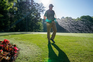 technician spraying lawn disease treatment on cave springs lawn